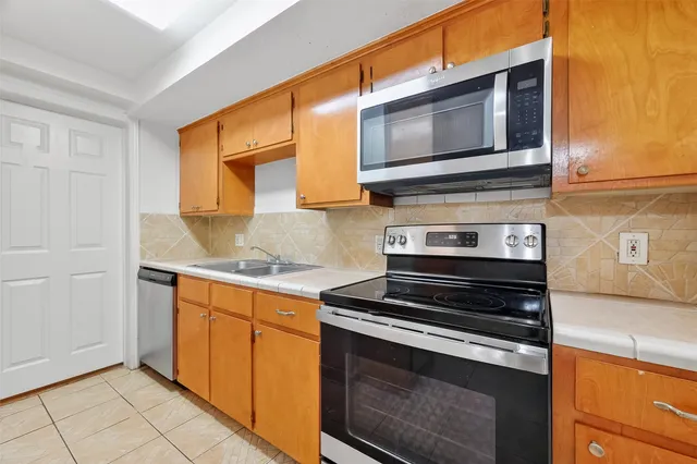 a kitchen with stainless steel appliances granite countertop a stove and a microwave