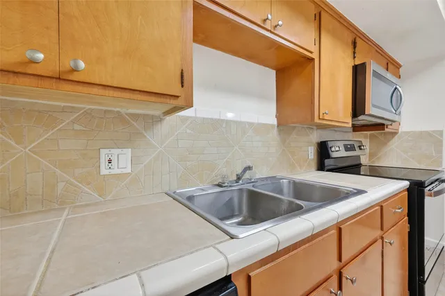 a kitchen with stainless steel appliances a sink a stove and a refrigerator
