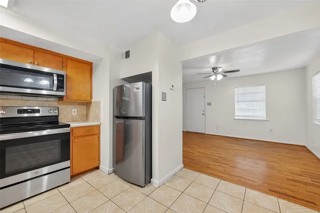 a kitchen with a refrigerator sink and cabinets