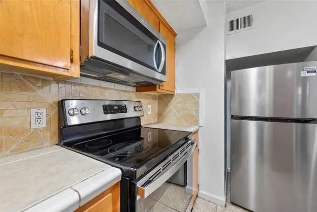 a close view of a stove top oven and refrigerator