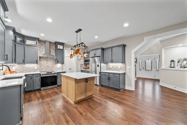 a large kitchen with stainless steel appliances lots of counter space and wooden floor