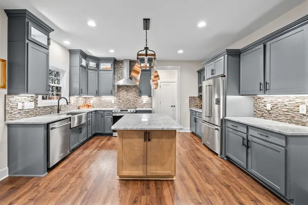 a kitchen with granite countertop a sink and a refrigerator