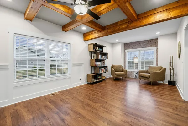 a view of an empty room with wooden floor and stairs