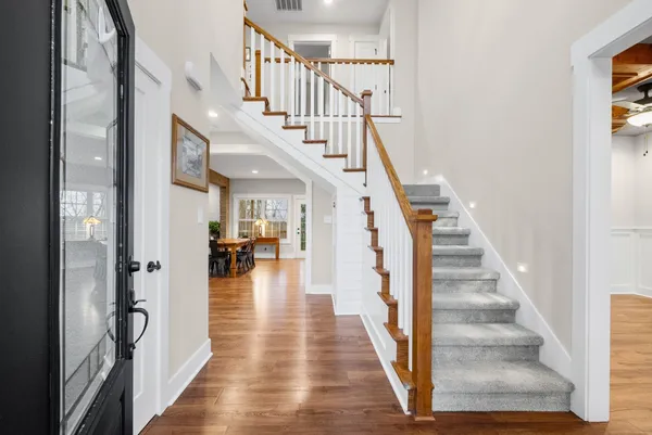 a dining hall with stainless steel appliances granite countertop a dining table chairs stove a sink and dishwasher
