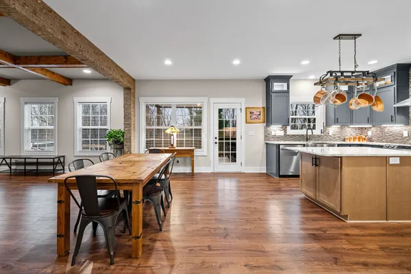 a living room with stainless steel appliances kitchen island granite countertop furniture wooden floor and a fireplace