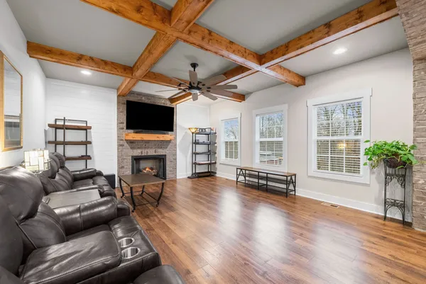 a living room with furniture a fireplace and a flat screen tv