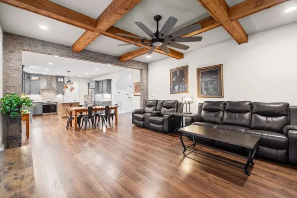 a large kitchen with granite countertop a stove top oven a sink a dining table and chairs