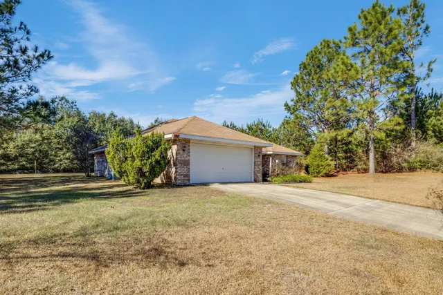 a view of a house with a yard and garage