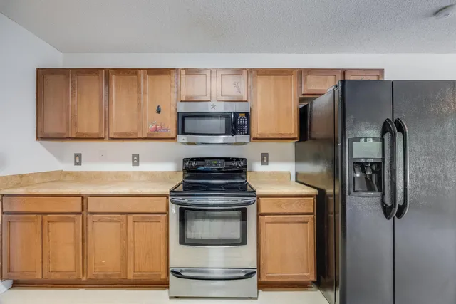 a kitchen with stainless steel appliances granite countertop a refrigerator stove and a sink