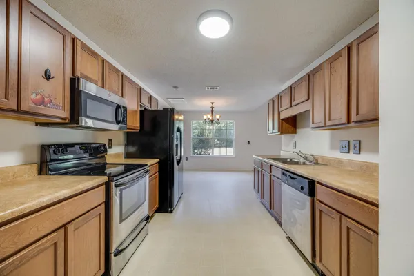 a kitchen with stainless steel appliances granite countertop a stove a sink and a refrigerator
