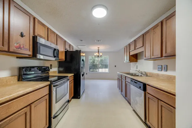 a kitchen with stainless steel appliances granite countertop a stove a sink and a refrigerator