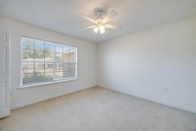 an empty room with a ceiling fan and a bathroom