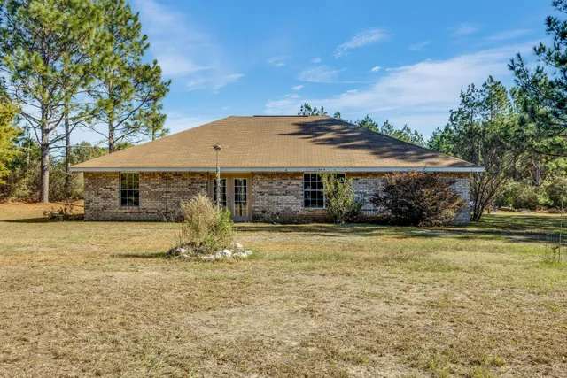 a yellow house with trees in front of it