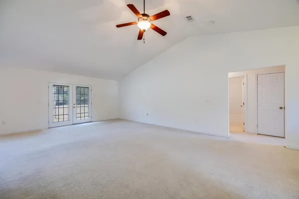 a view of a big room with windows and ceiling fan