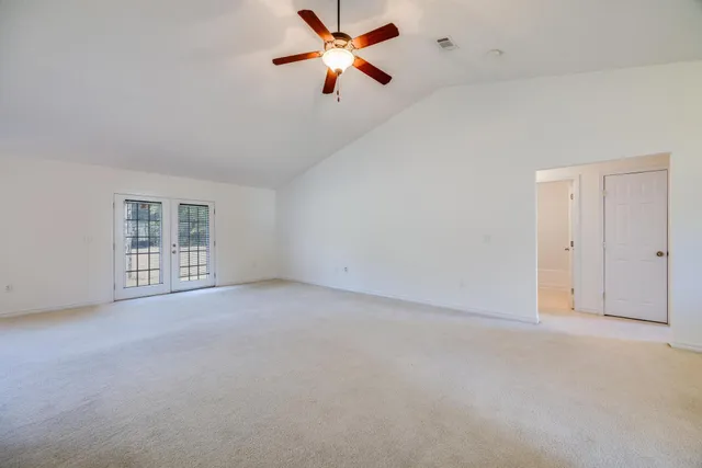 a view of a big room with windows and ceiling fan