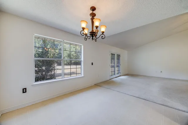 a view of a livingroom with a chandelier fan and a window