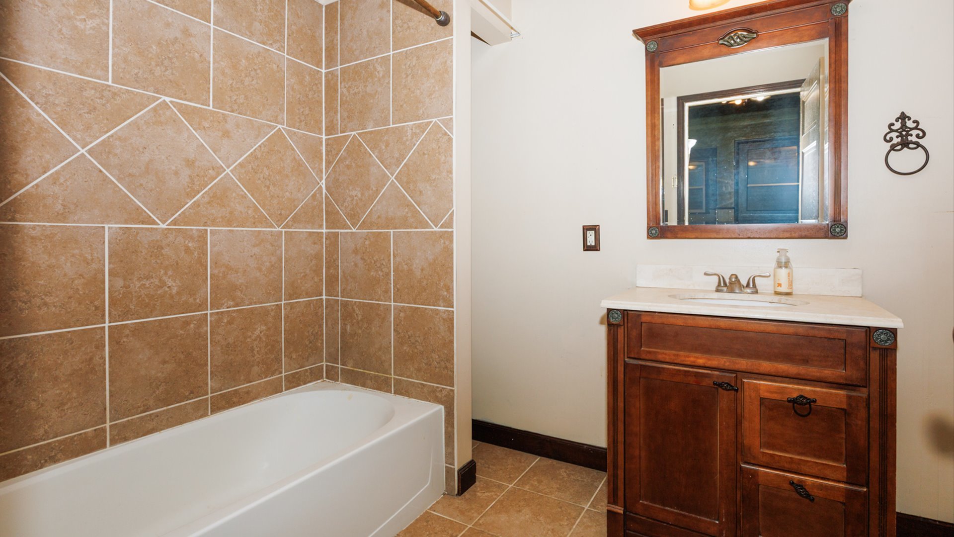 517 North Walnut Street Clinton, IL 61727 - Photo 19 of 29 a bathroom with a bathtub a mirror a sink and vanity