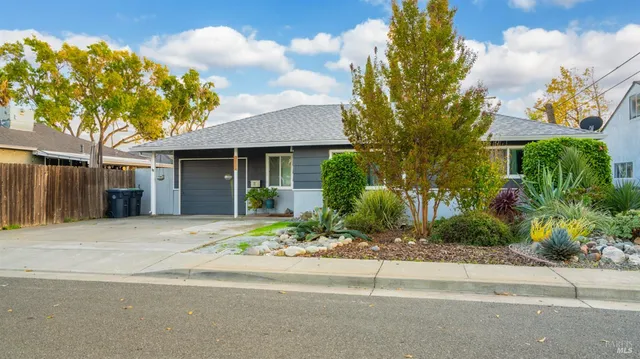 a front view of a house with a yard and a garage