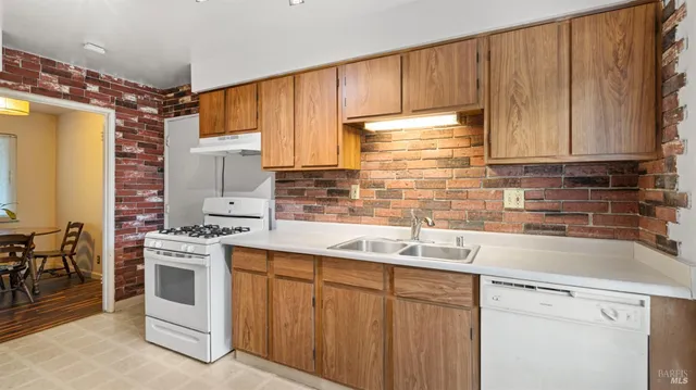 a kitchen with stainless steel appliances a sink cabinets and a window