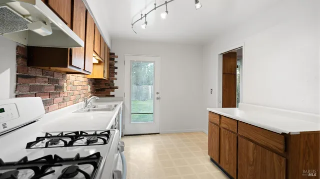 a kitchen with a sink and a stove top oven