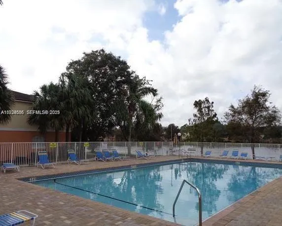 a view of a swimming pool with lake and trees in the background