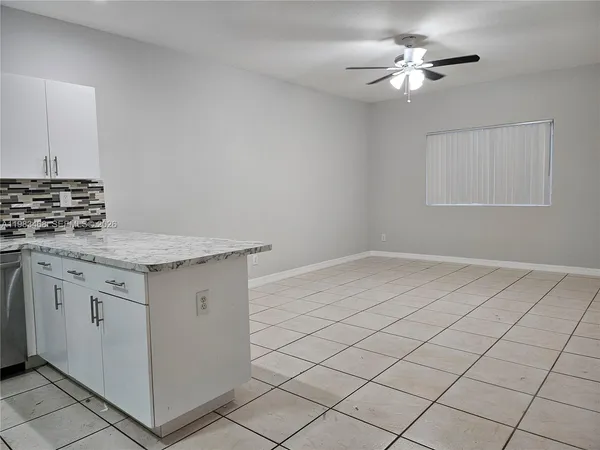 a kitchen with granite countertop white cabinets and white appliances
