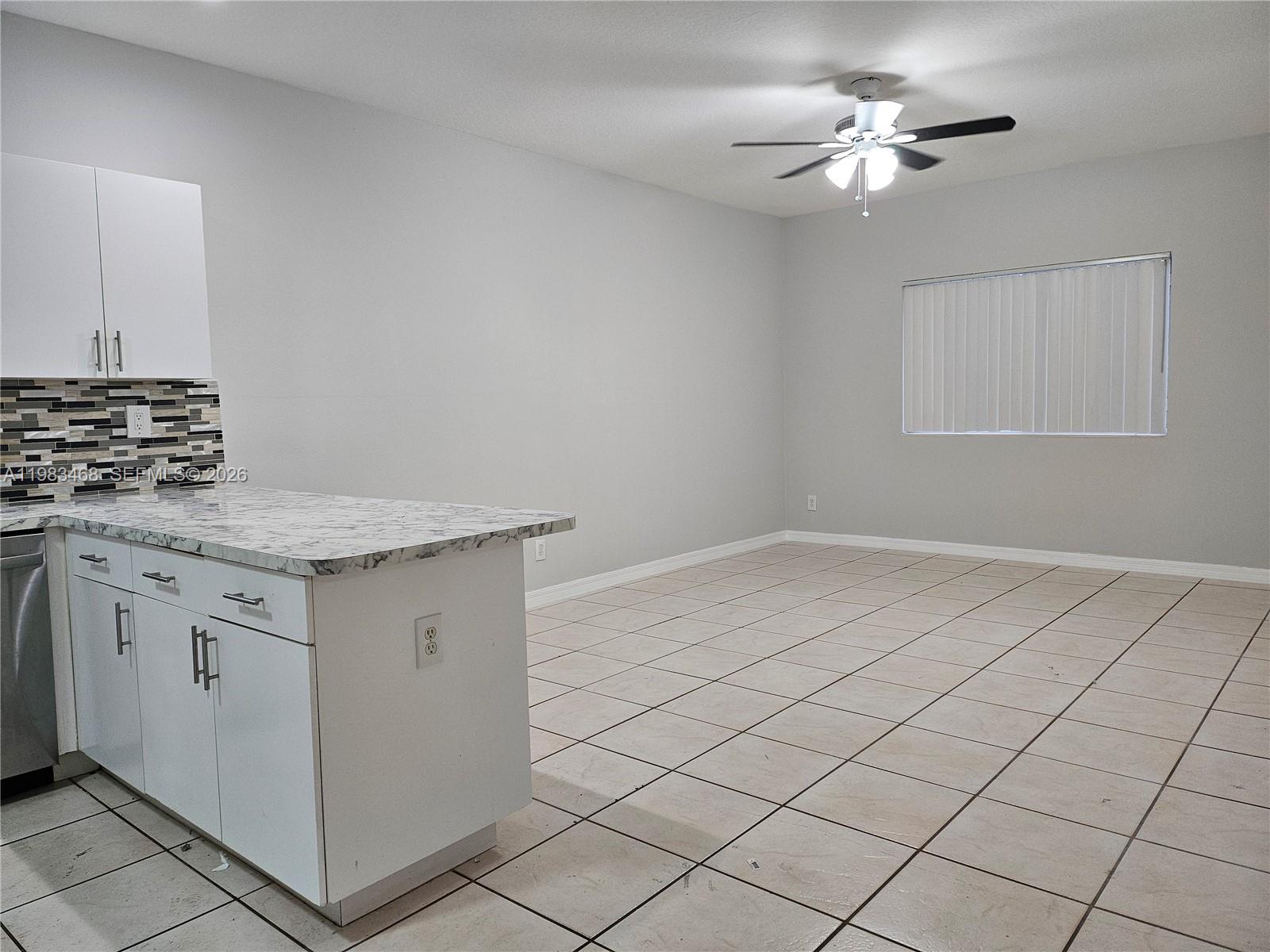 14924 Southwest 58th Street Miami, FL 33193 - Photo 5 of 17 a kitchen with granite countertop white cabinets and white appliances