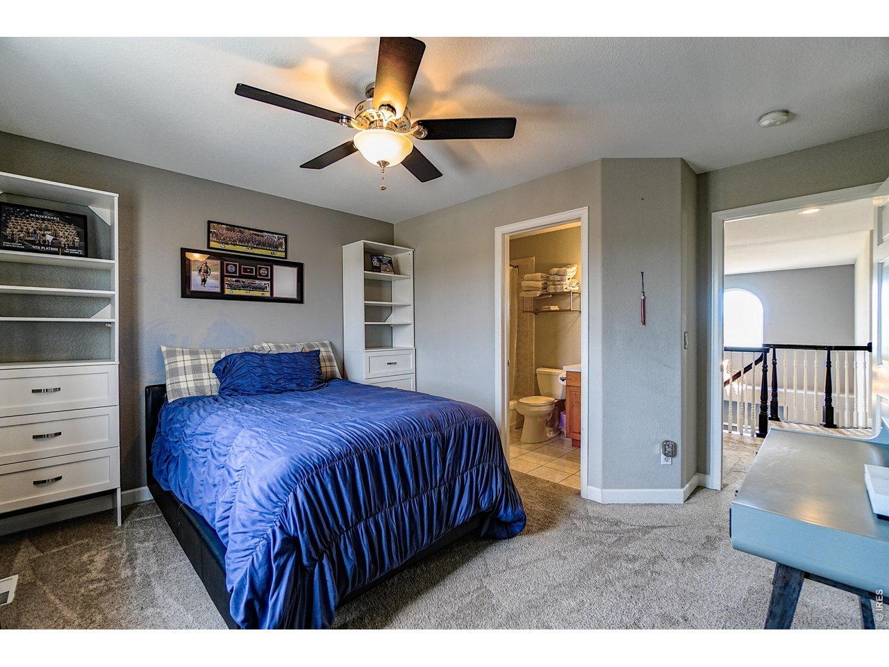 3938 Vale View Lane Mead, CO 80542 - Photo 30 of 49 a bedroom with a large bed and a chandelier