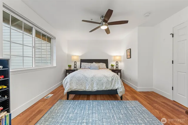a bedroom with a bed and wooden floor
