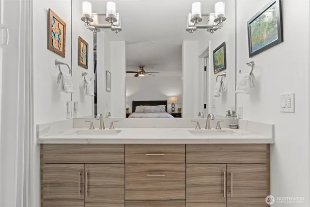 a bathroom with a double vanity sink mirror and bathtub