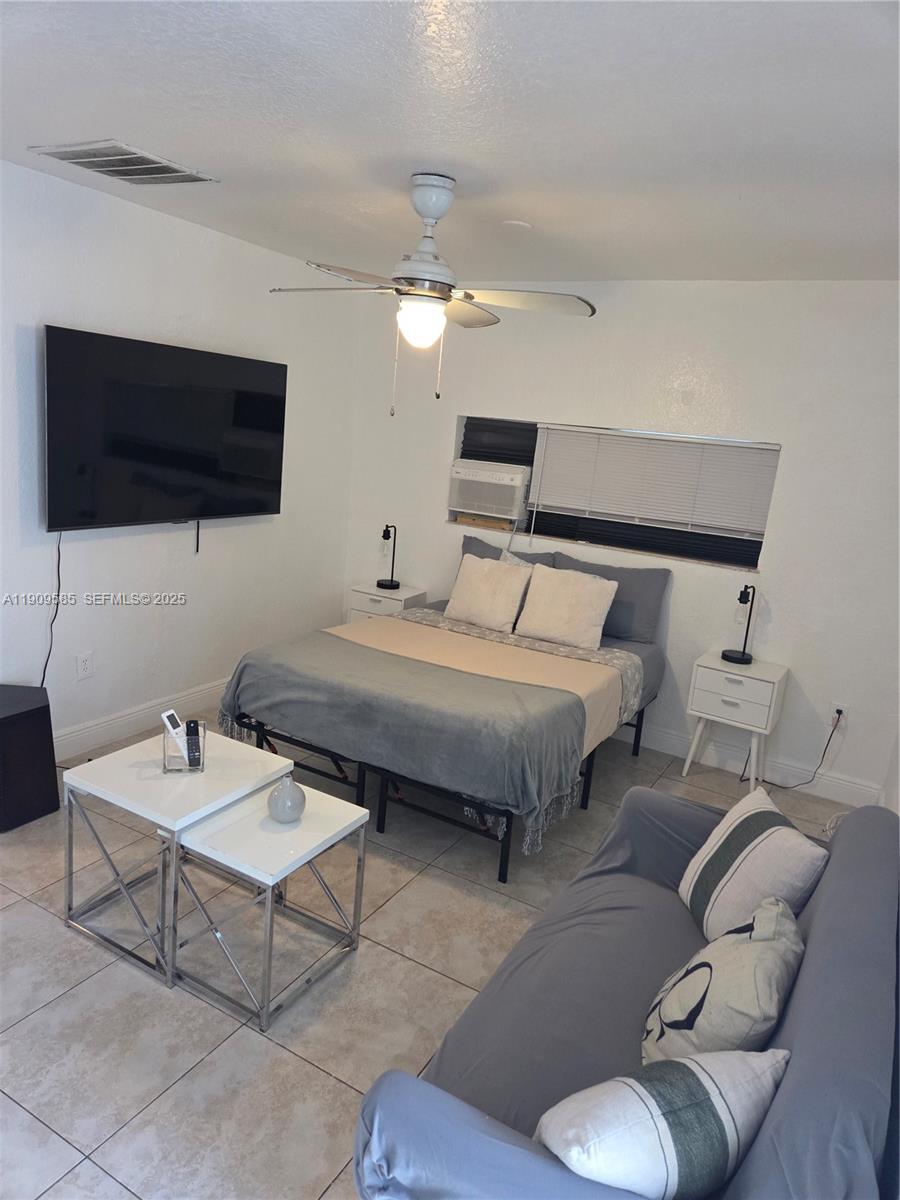 2972 Northwest 15th Street, Unit 2 Miami, FL 33125 - Photo 11 of 17 a bedroom with a bed a couch and a flat screen tv