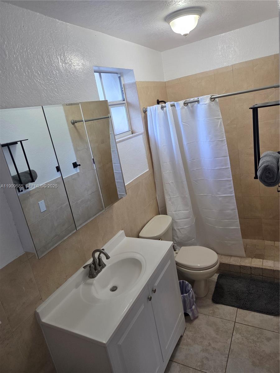2972 Northwest 15th Street, Unit 2 Miami, FL 33125 - Photo 12 of 17 a bathroom with a sink and mirror with toilet
