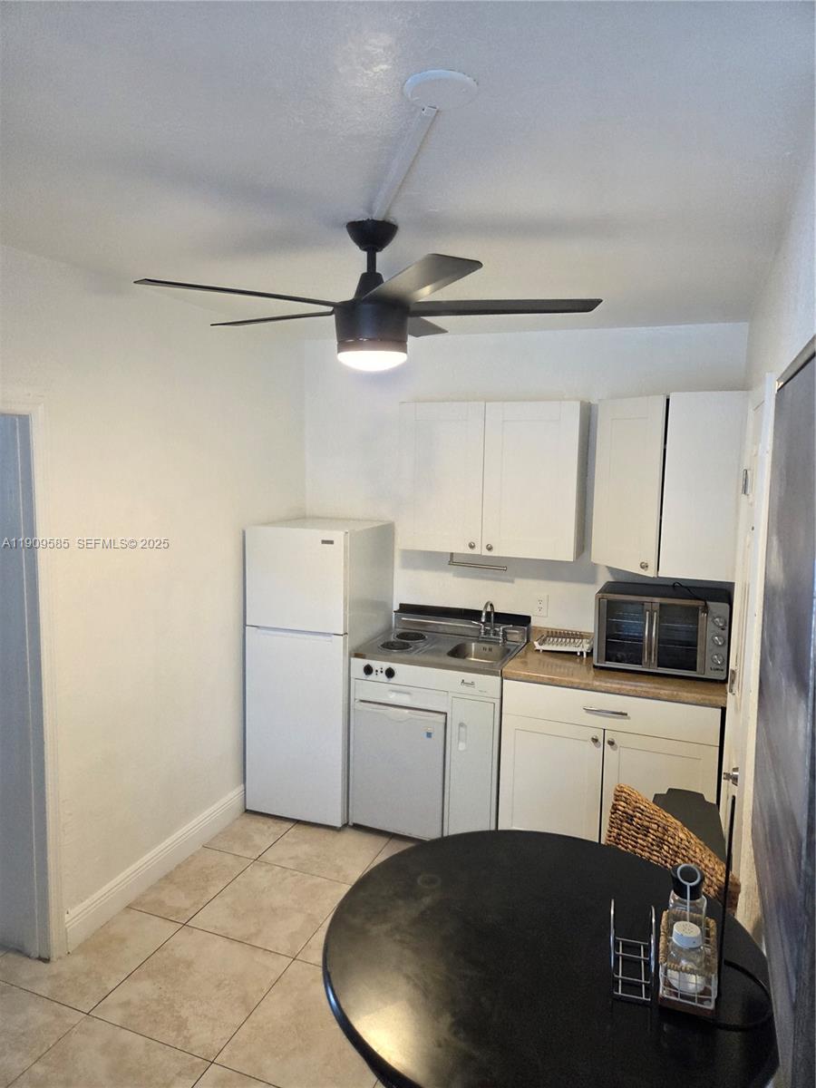 2972 Northwest 15th Street, Unit 2 Miami, FL 33125 - Photo 16 of 17 a kitchen with a sink a stove cabinets and a refrigerator
