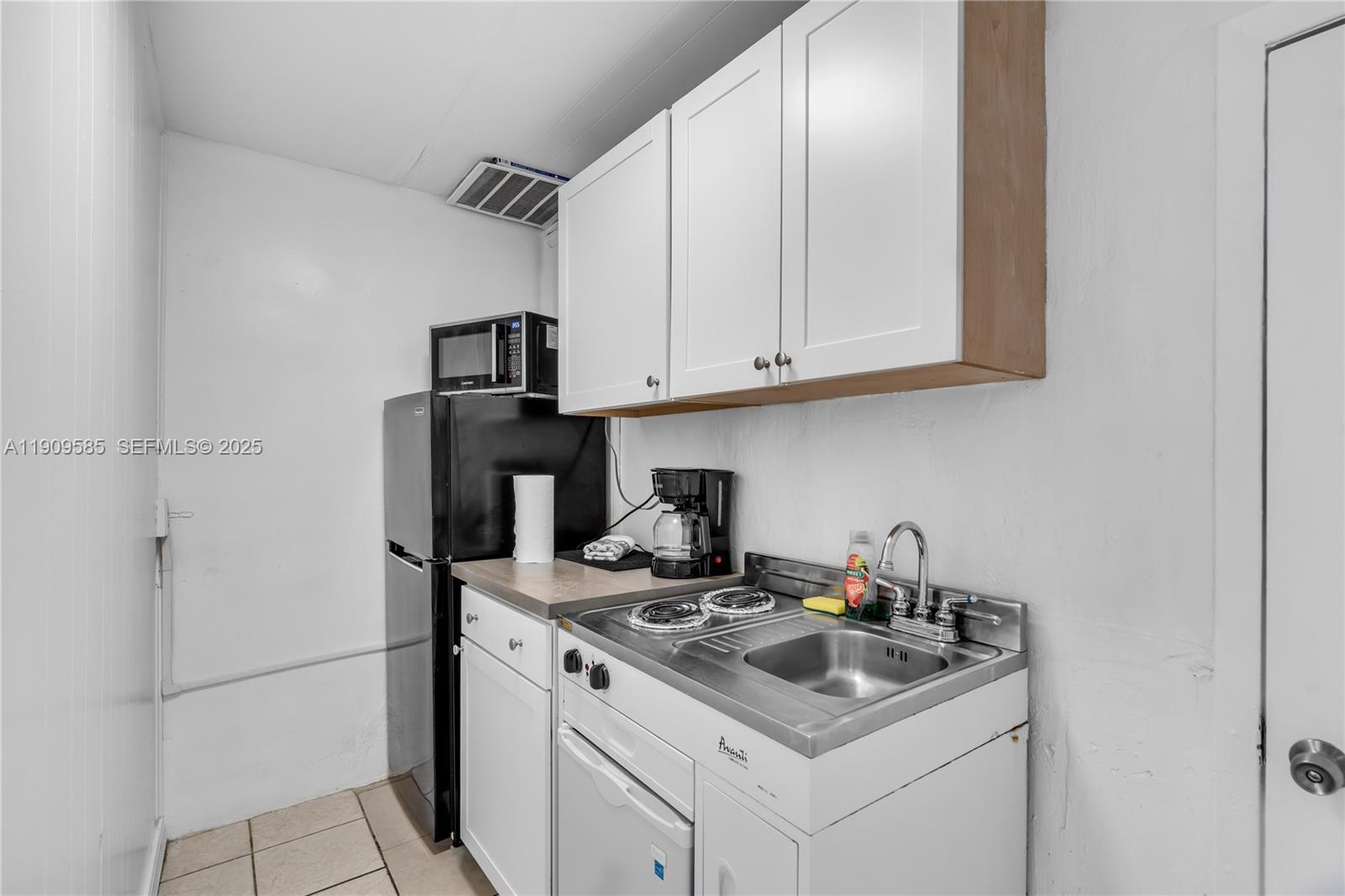 2972 Northwest 15th Street, Unit 2 Miami, FL 33125 - Photo 7 of 17 a kitchen with stainless steel appliances granite countertop a sink stove and refrigerator