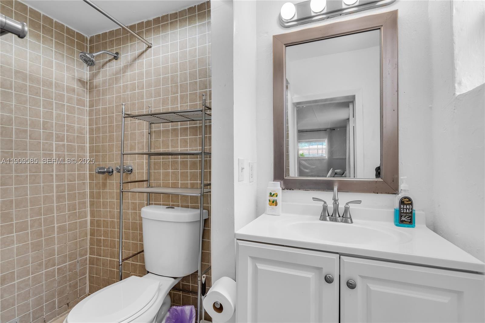 2972 Northwest 15th Street, Unit 2 Miami, FL 33125 - Photo 9 of 17 a bathroom with a sink a toilet and a mirror