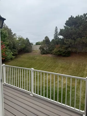 a view of a balcony with wooden floor and fence
