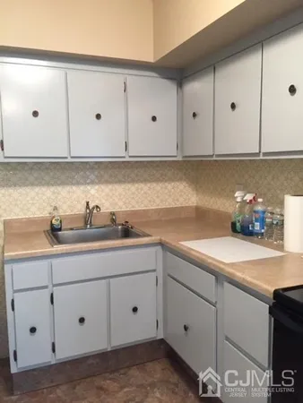 a kitchen with white cabinets white stainless steel appliances and sink