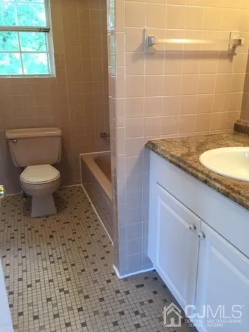 a bathroom with a granite countertop toilet a sink and a shower