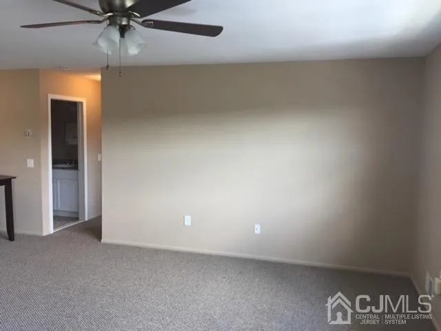 an empty room with a ceiling fan and window