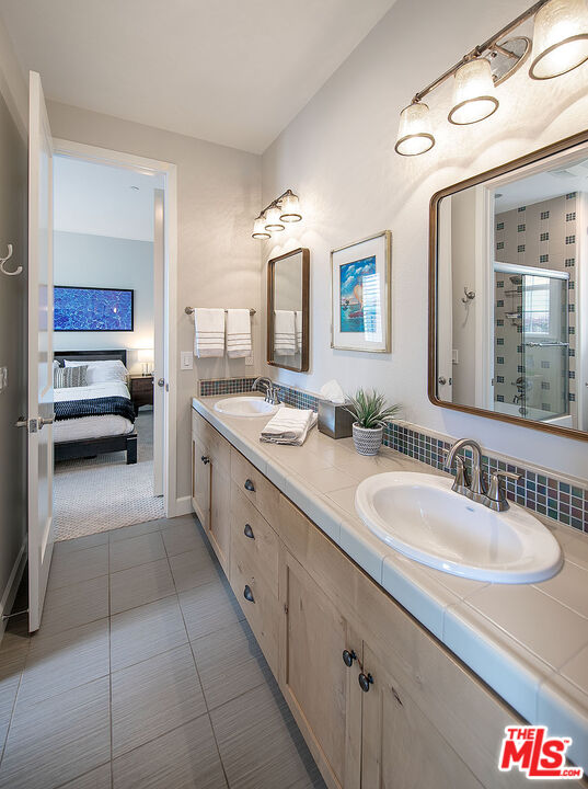6372 Lagunitas Court Carpinteria, CA 93013 - Photo 14 of 19 a spacious en suite bathroom with a granite countertop sink mirror and bathtub