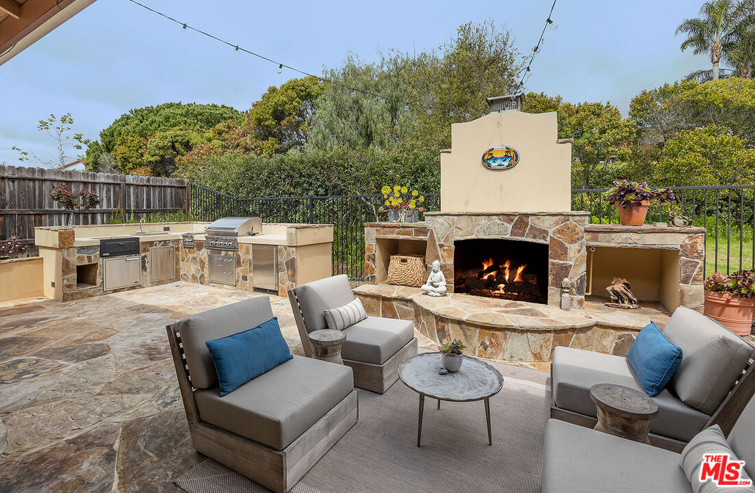 6372 Lagunitas Court Carpinteria, CA 93013 - Photo 16 of 19 a outdoor space with patio fireplace couches and a potted plant