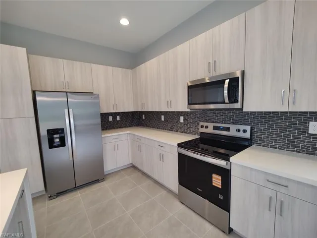 a kitchen with stainless steel appliances granite countertop a sink and a wooden cabinets