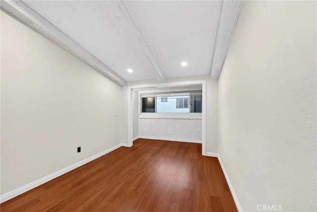 a view of a room with wooden floor and white walls