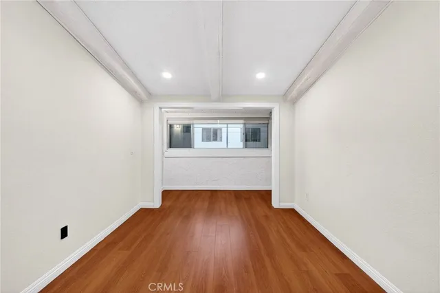 a big room with wooden floor and windows