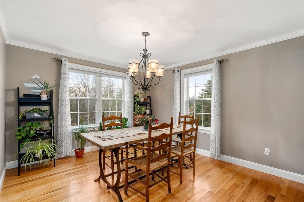 10 Brook Hill Road Sturbridge, MA 01518 - Photo 15 of 35 a dining room with wooden floor a chandelier a glass table and chairs