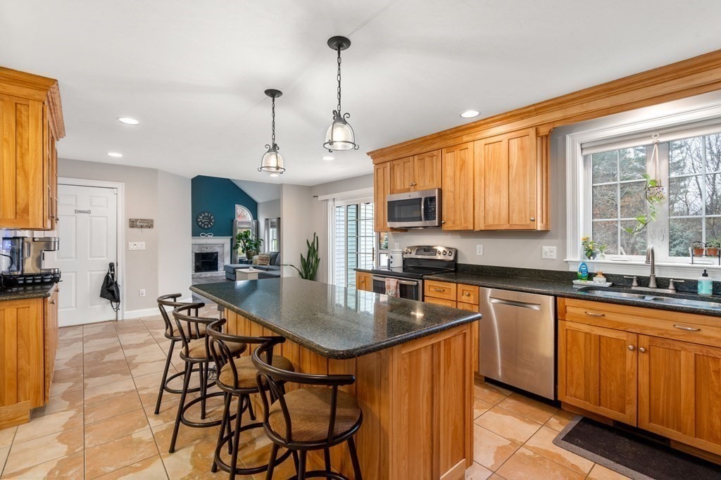 10 Brook Hill Road Sturbridge, MA 01518 - Photo 9 of 35 a kitchen with stainless steel appliances granite countertop a stove a sink a refrigerator white cabinets with a dining table and chairs