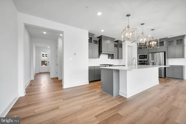 a view of a kitchen with refrigerator and wooden floor