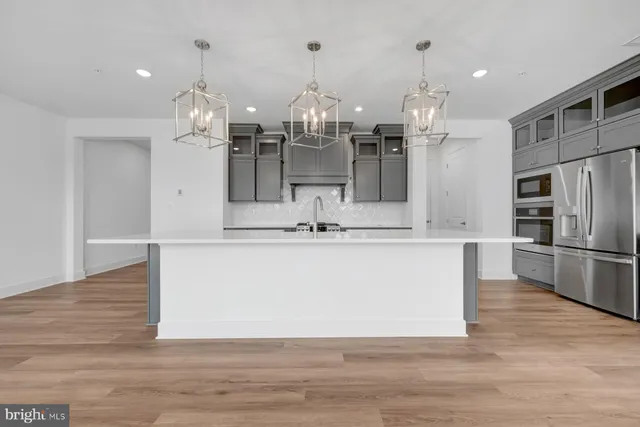 a view of a kitchen with wooden floor and refrigerator