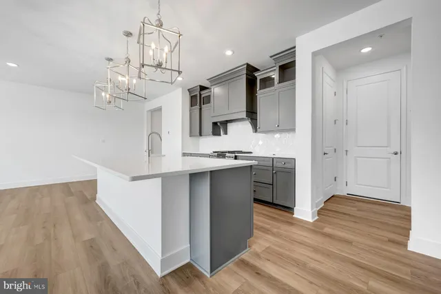 a kitchen with kitchen island a sink and a stove