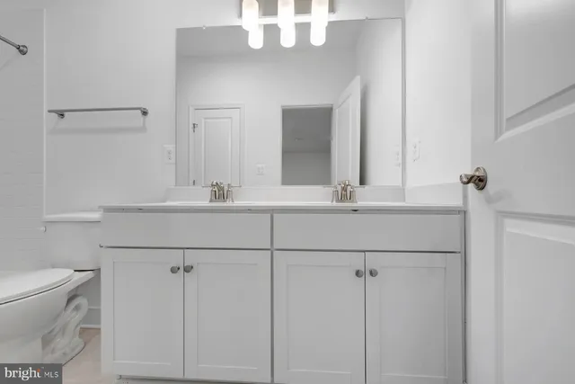 a bathroom with a sink a toilet and mirror